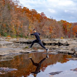 Jumping from rock to rock at Ohiopyle in the Fall.